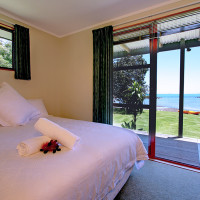 Coopers Beach Romantic Accommodation. Main bedroom in Pohutukawa Cottage